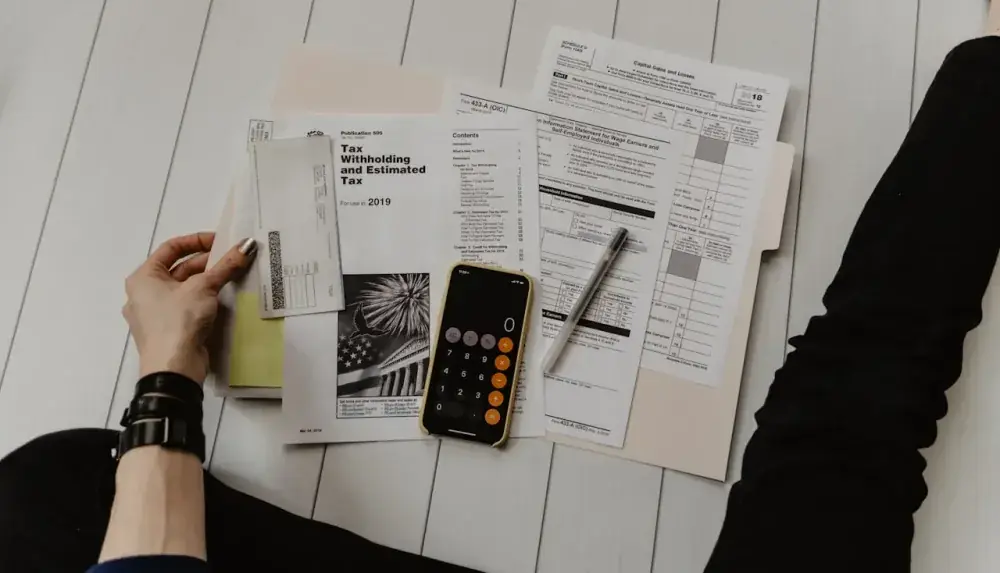 Calculadora e planilha de simulação de financiamento sobre mesa com planta de apartamento